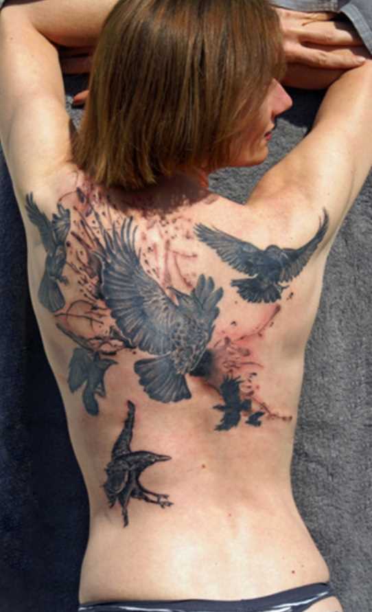 Tatuagem nas costas de uma menina - corvos