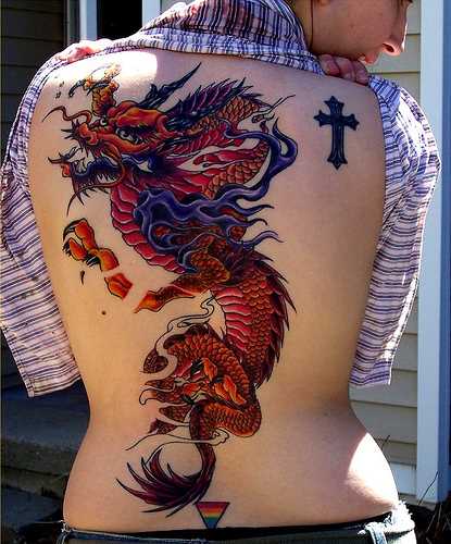 Tatuagem nas costas de uma menina de dragão, e a cruz
