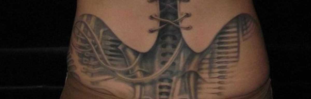 Tatuagem nas costas de uma menina no estilo de biomecânica