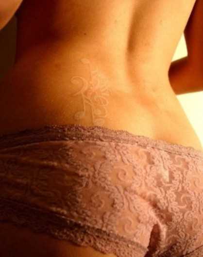 Tatuagem nas costas de uma menina notas e a clave de sol