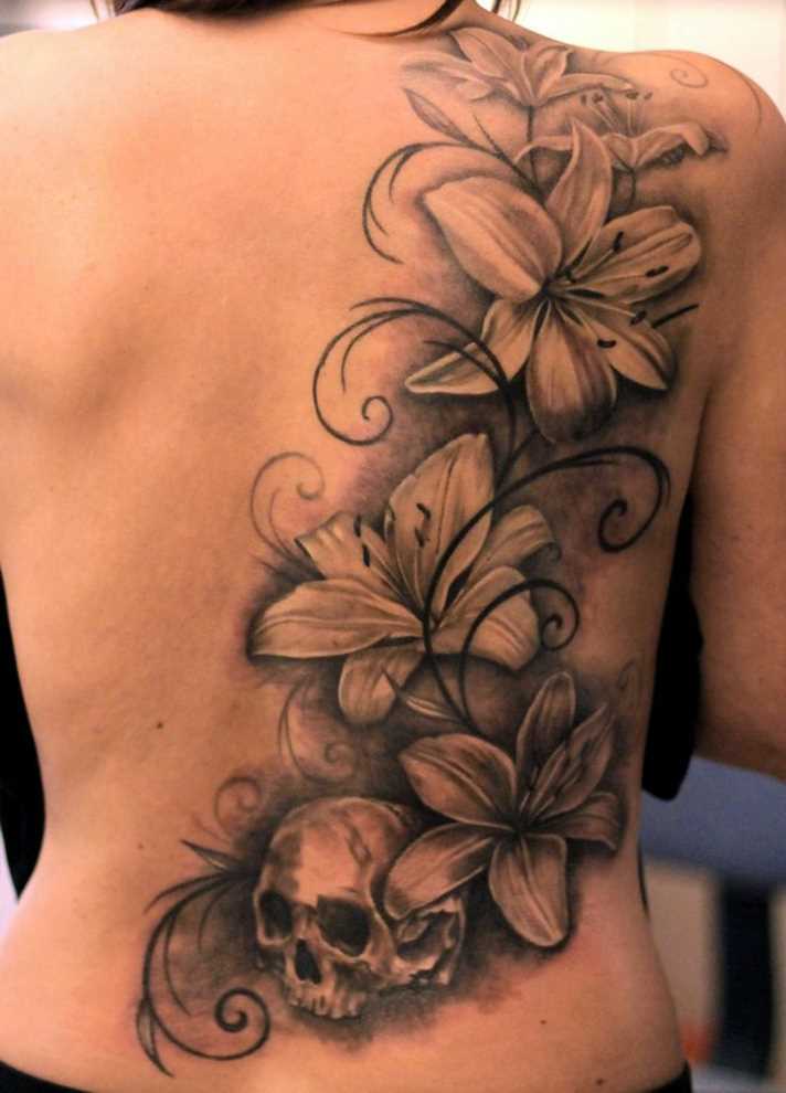 Tatuagem nas costas de uma menina - o lírio e o crânio
