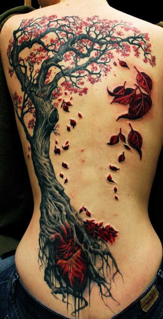 Tatuagem nas costas de uma menina - uma árvore com folhas opadaiushchimi