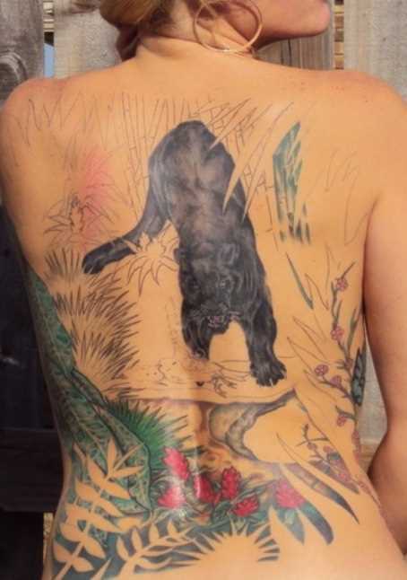 Tatuagem nas costas de uma menina - uma pantera à beira do rio