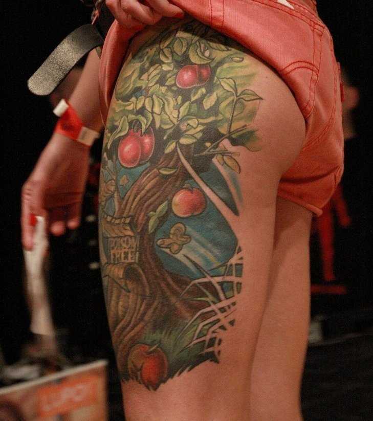 Tatuagem nas coxas da menina - árvore com maçãs