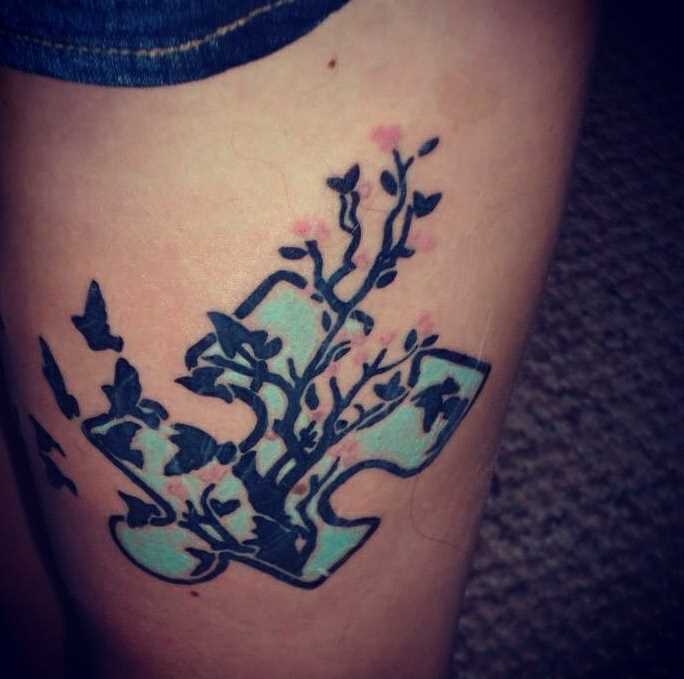 Tatuagem nas coxas da menina - cabeça com a árvore