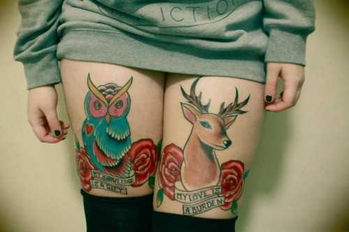 Tatuagem nas coxas da menina - o cervo, o coruja, rosas e inscrição