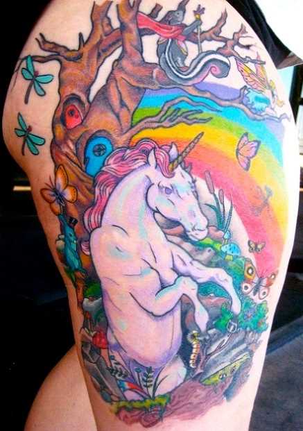 Tatuagem nas coxas da menina - o unicórnio e o arco-íris