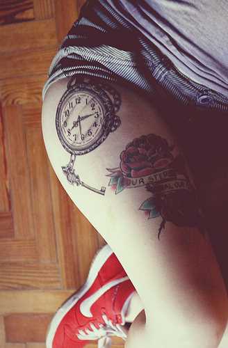 Tatuagem nas coxas da menina - relógio, chave e rosas