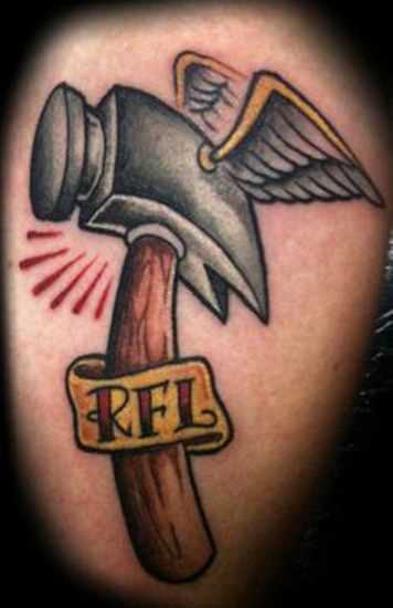 Tatuagem nas coxas do cara - de-martelo com asas e inscrição