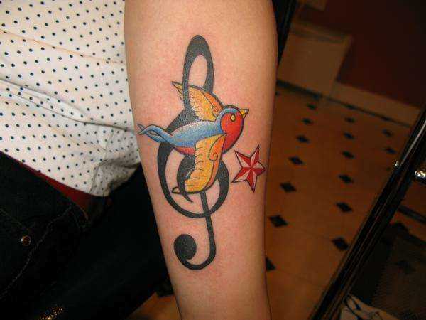 Tatuagem no antebraço, as meninas - clave de sol, a andorinha e a estrela