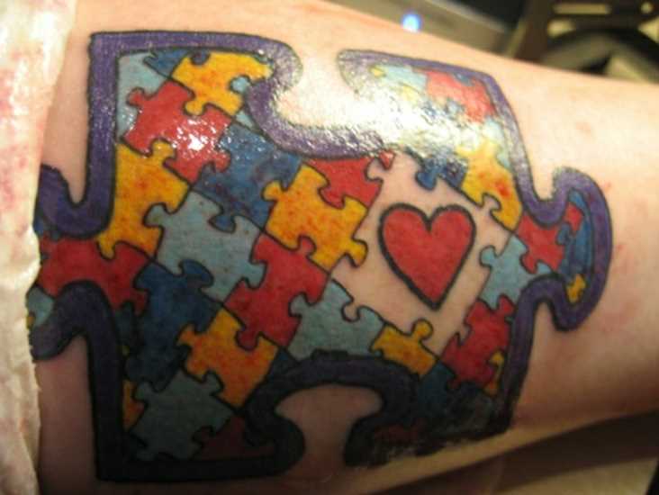 Tatuagem no antebraço de uma menina de quebra - cabeça na forma de pequenos quebra-cabeças