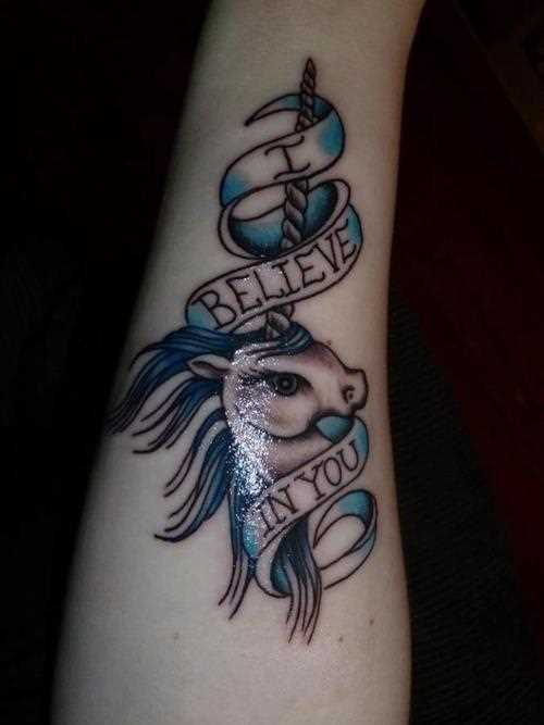 Tatuagem no antebraço de uma menina - o unicórnio e a inscrição