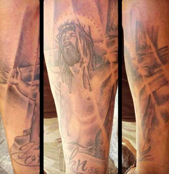 Tatuagem no antebraço do cara - a cruz e o crucificado Jesus