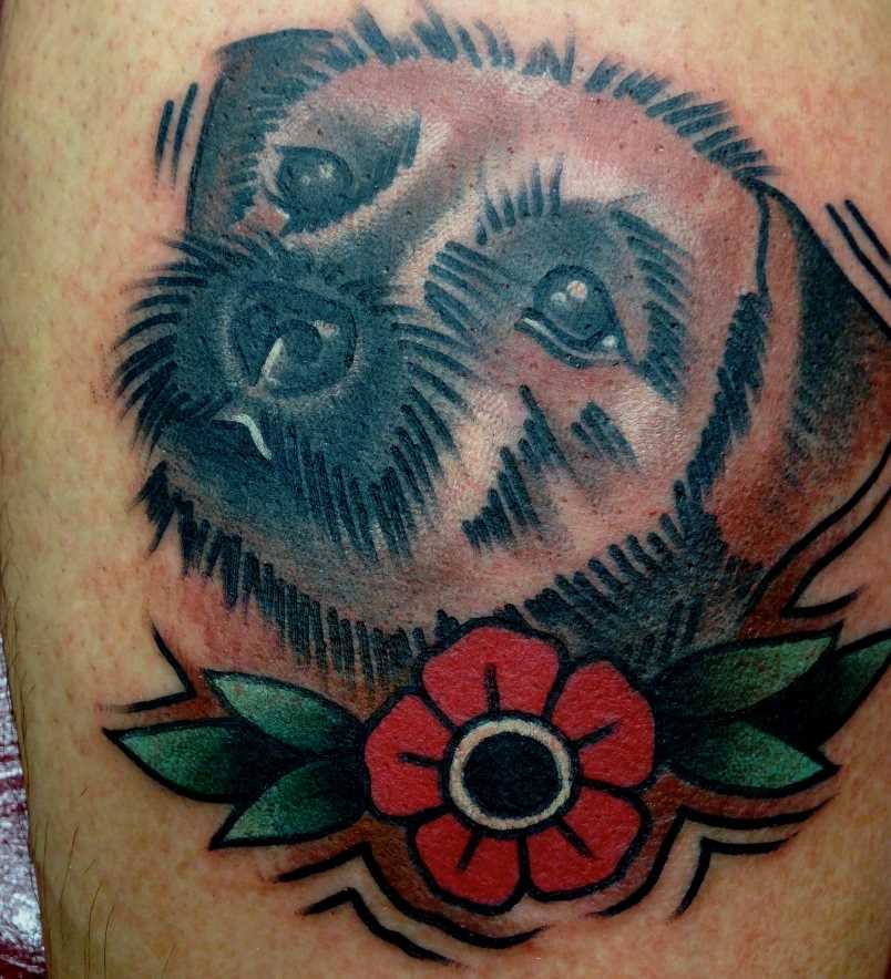 Tatuagem no antebraço do cara - de- cão com uma flor