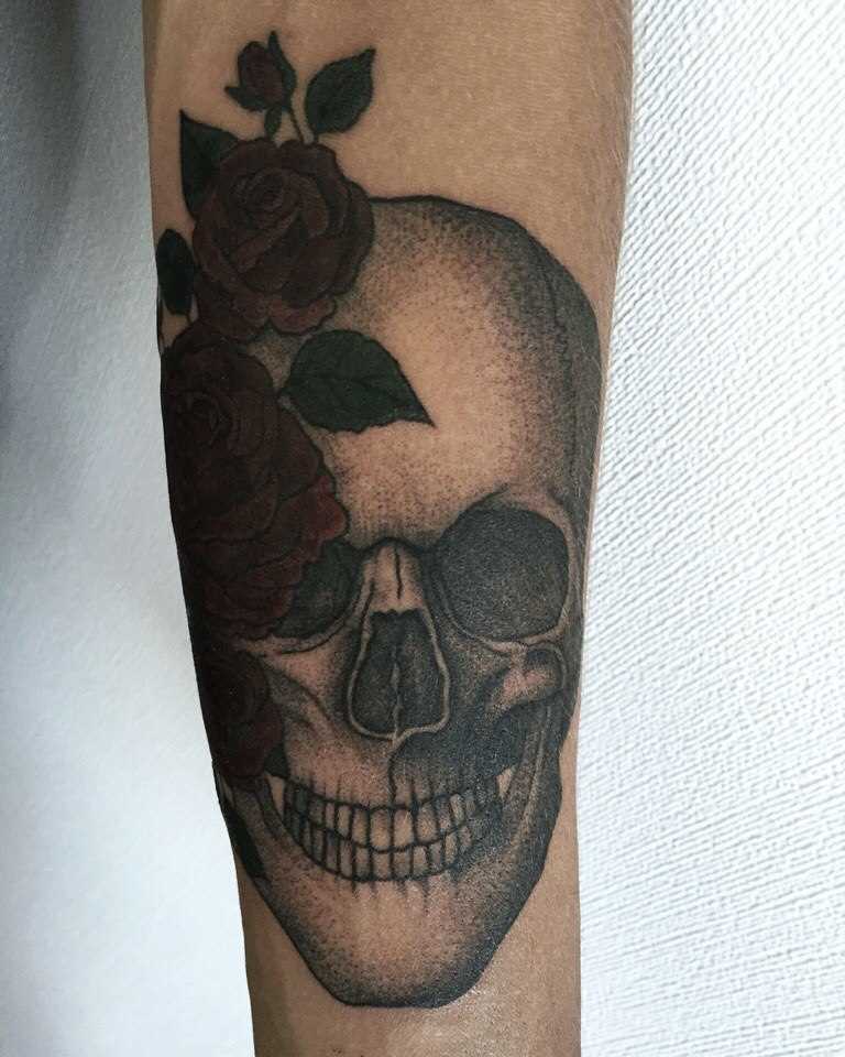 Tatuagem no antebraço tenha uma cara de crânio e rosas