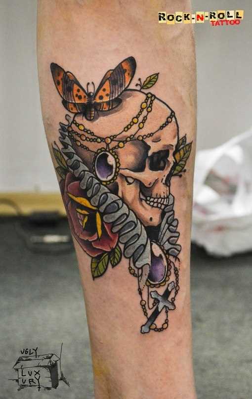 Tatuagem no antebraço tenha uma cara de crânio e uma borboleta