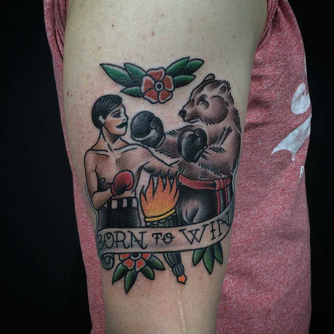 Tatuagem no braço de um cara - boxeador com um urso