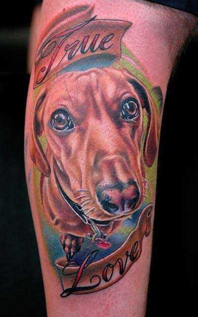 Tatuagem no braço de um cara - de- cão e inscrição