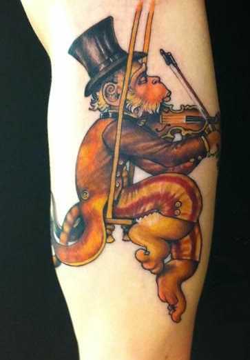 Tatuagem no braço de um cara de macaco com violino