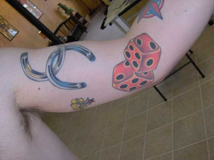 Tatuagem no braço de um cara - duas ferraduras
