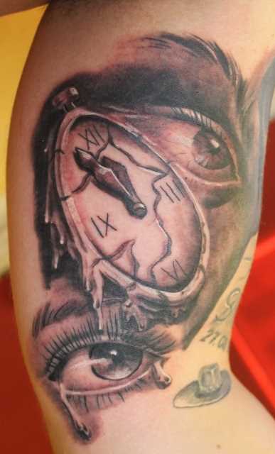 Tatuagem no braço de um cara - relógio e os olhos