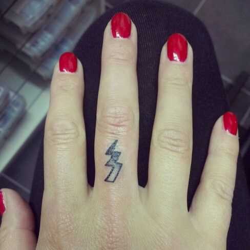 Tatuagem no dedo de uma menina - relâmpago