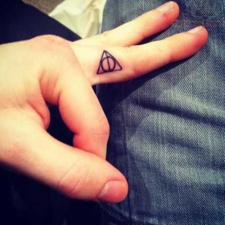 Tatuagem no dedo de uma menina - triângulo com um círculo
