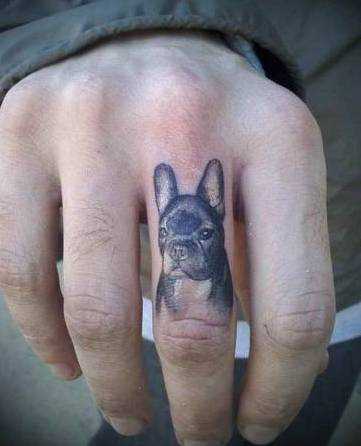 Tatuagem no dedo do cara - a cabeça de um cão