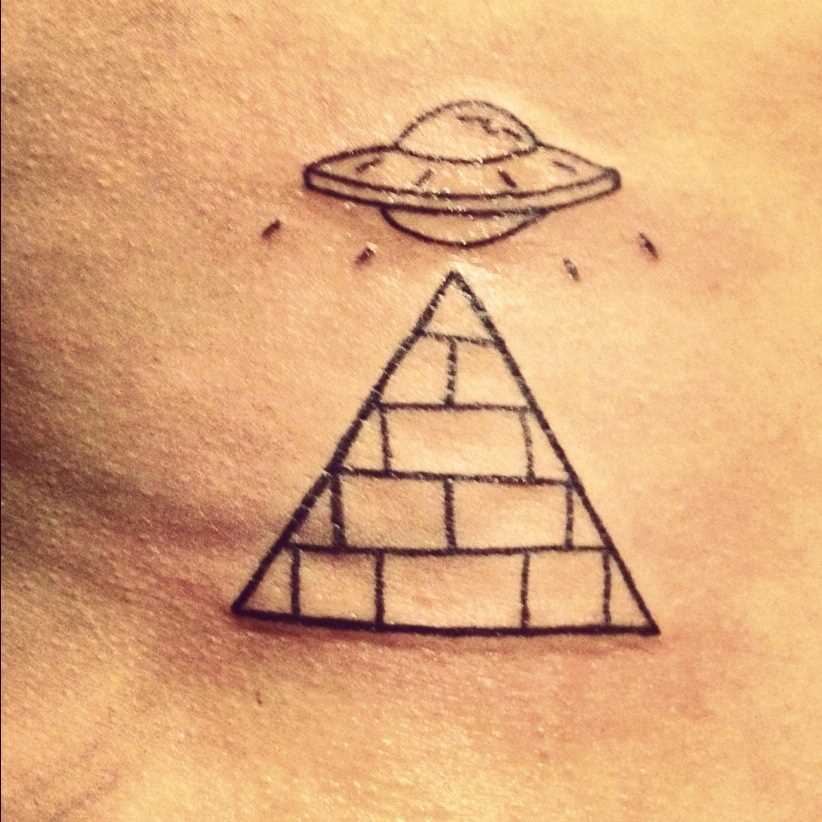 Tatuagem no lado da menina - a pirâmide e o disco voador