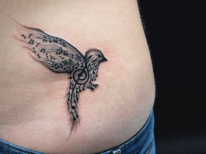 Tatuagem no lado da menina - as notas da clave de sol e o pássaro