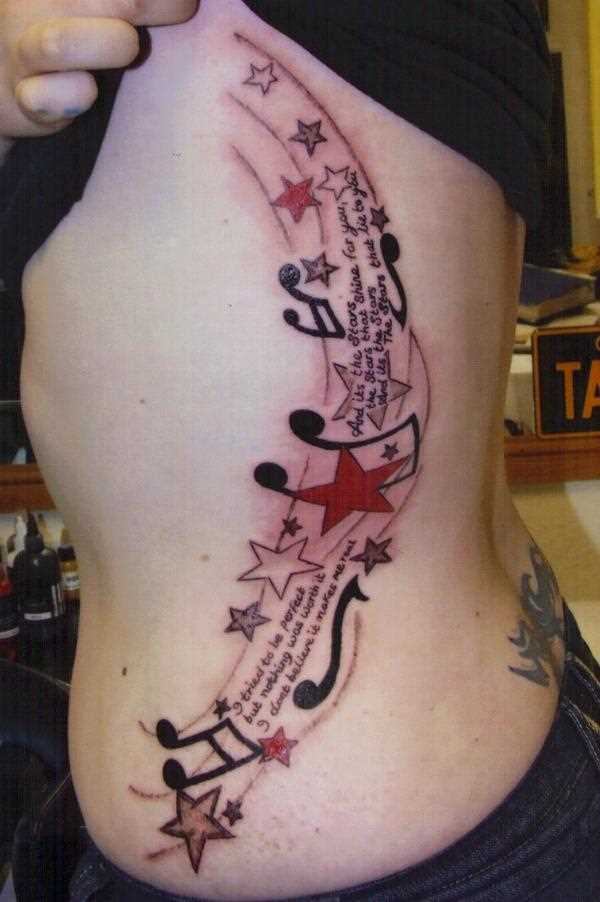 Tatuagem no lado da menina - as notas e as estrelas