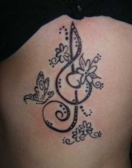 Tatuagem no lado da menina - clave de sol, flores e borboleta
