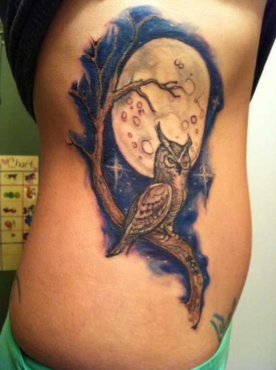 Tatuagem no lado da menina - da-lua e uma coruja no galho de uma árvore