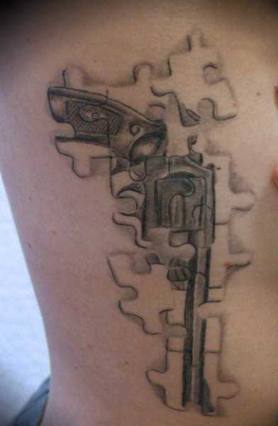 Tatuagem no lado da menina de quebra - cabeça na forma de uma pistola