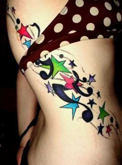 Tatuagem no lado da menina notas e estrelas coloridas