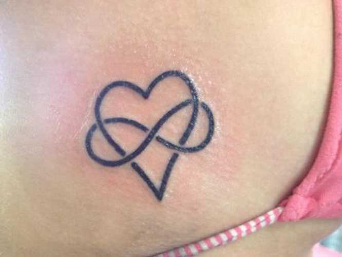 Tatuagem no lado da menina - o coração e o símbolo do infinito