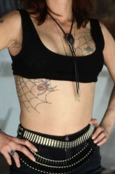 Tatuagem no lado da menina - uma teia de aranha e a aranha
