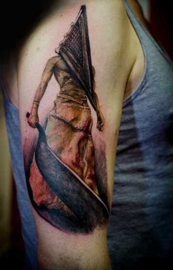 Tatuagem no ombro da menina - a pirâmide em forma de uma cabeça de homem com uma espada