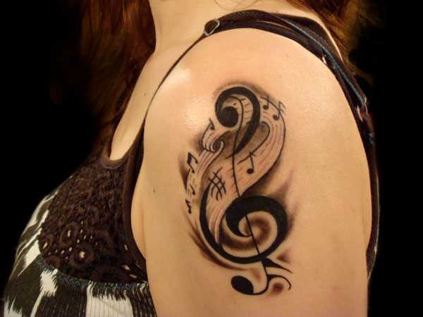 Tatuagem no ombro da menina - clave de sol e notas