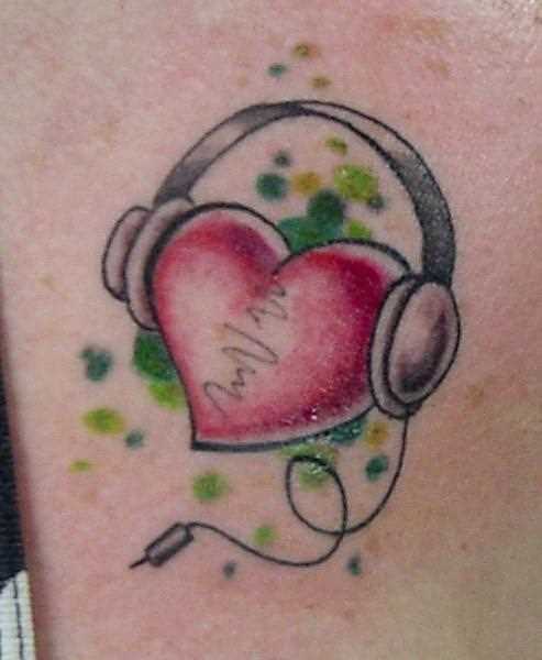 Tatuagem no ombro da menina - coração em fones de ouvido