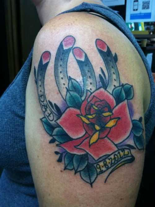 Tatuagem no ombro da menina - duas ferraduras e rosa