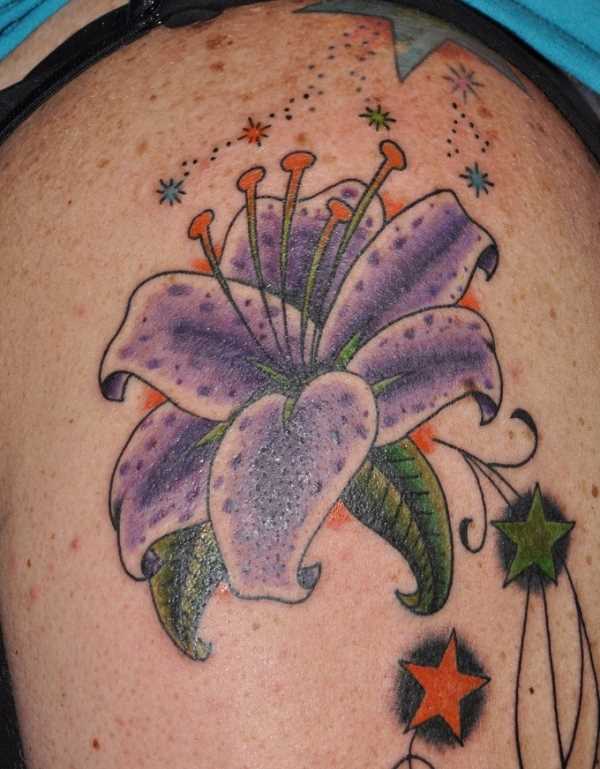 Tatuagem no ombro da menina em forma de lírios e as estrelas
