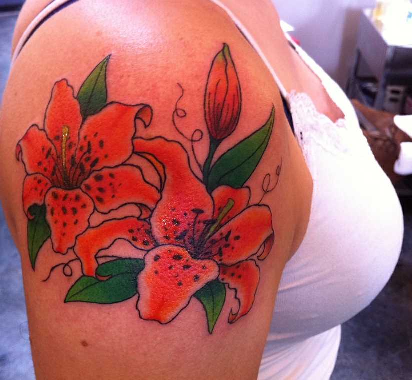 Tatuagem no ombro da menina em forma de lírios tigrovykh