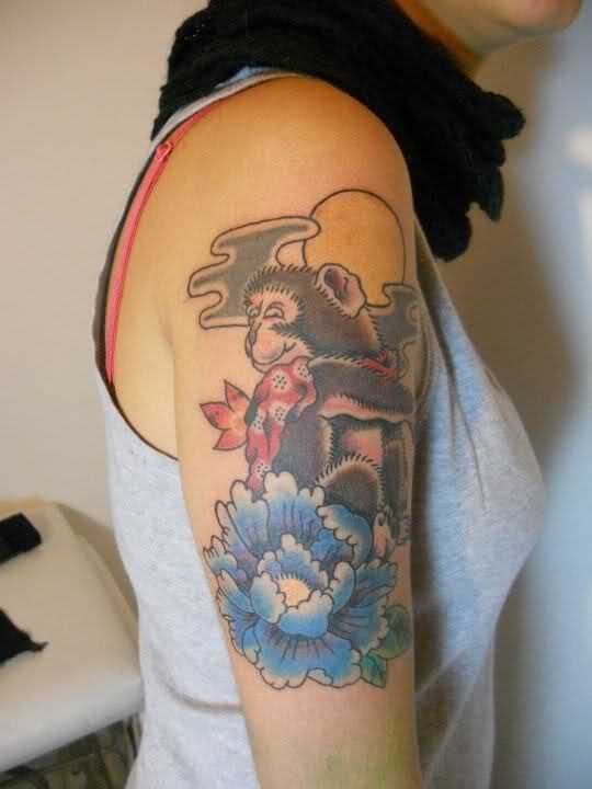 Tatuagem no ombro da menina - macaco, e a flor