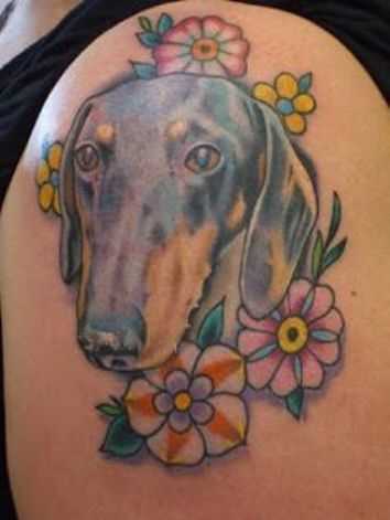 Tatuagem no ombro da menina - o cão e a cores