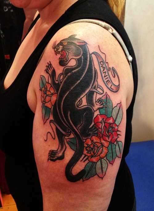 Tatuagem no ombro da menina - pantera, rosas e inscrição