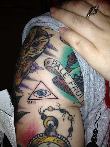 Tatuagem no ombro da menina - triângulo com o olho de