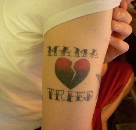 Tatuagem no ombro da menina - um coração partido e inscrição