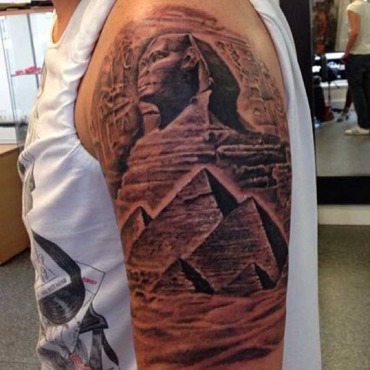 Tatuagem no ombro de um cara - a esfinge e as pirâmides