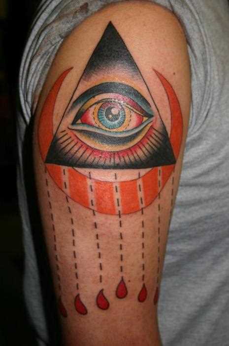 Tatuagem no ombro de um cara - a pirâmide com o olho e a lua